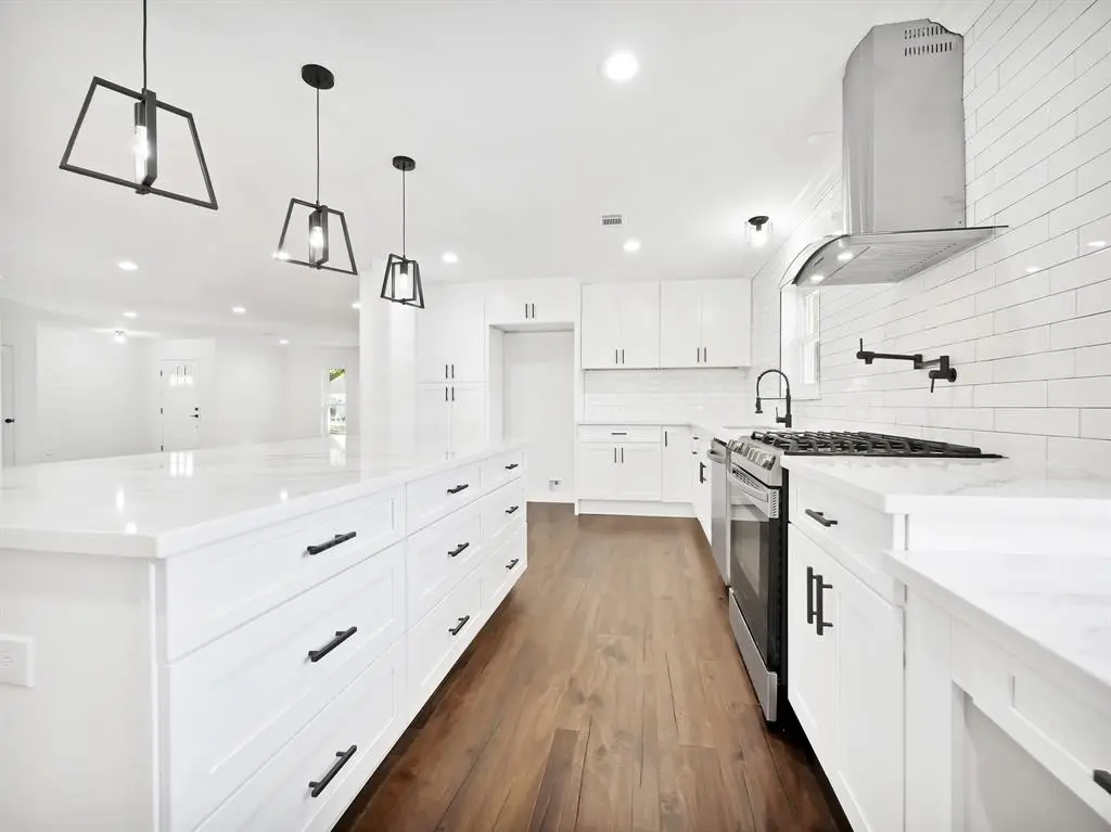 Bright white shaker cabinets with large island and black hardware