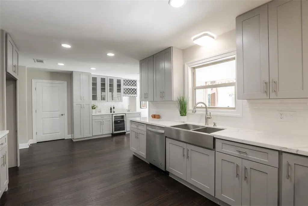 Soft gray shaker cabinets with farmhouse sink and glass uppers